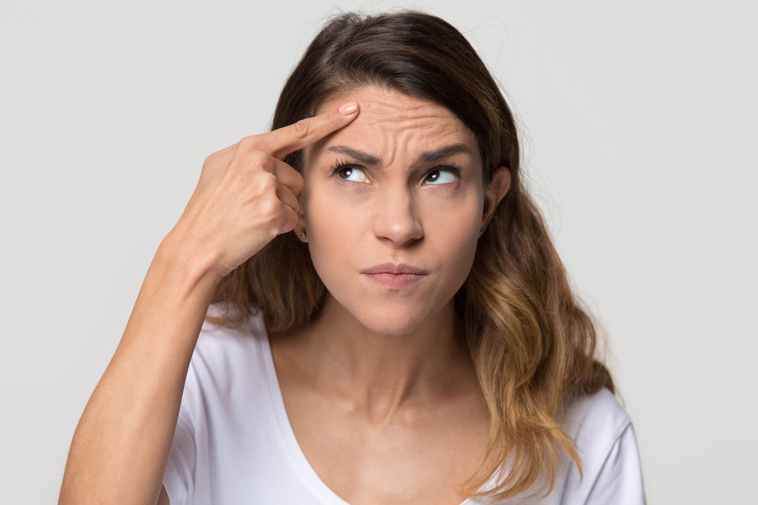 Young woman touching forehead worried about skin wrinkle - Brow Lift